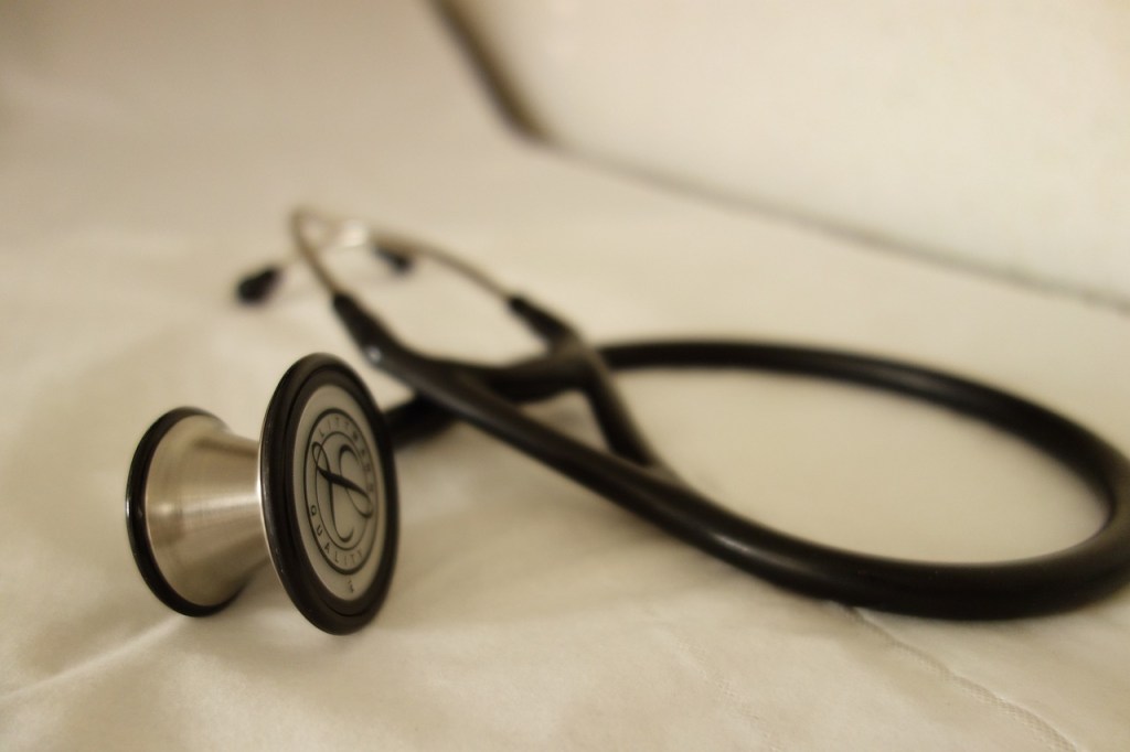 A Littmann Stethoscope laying on a table. 