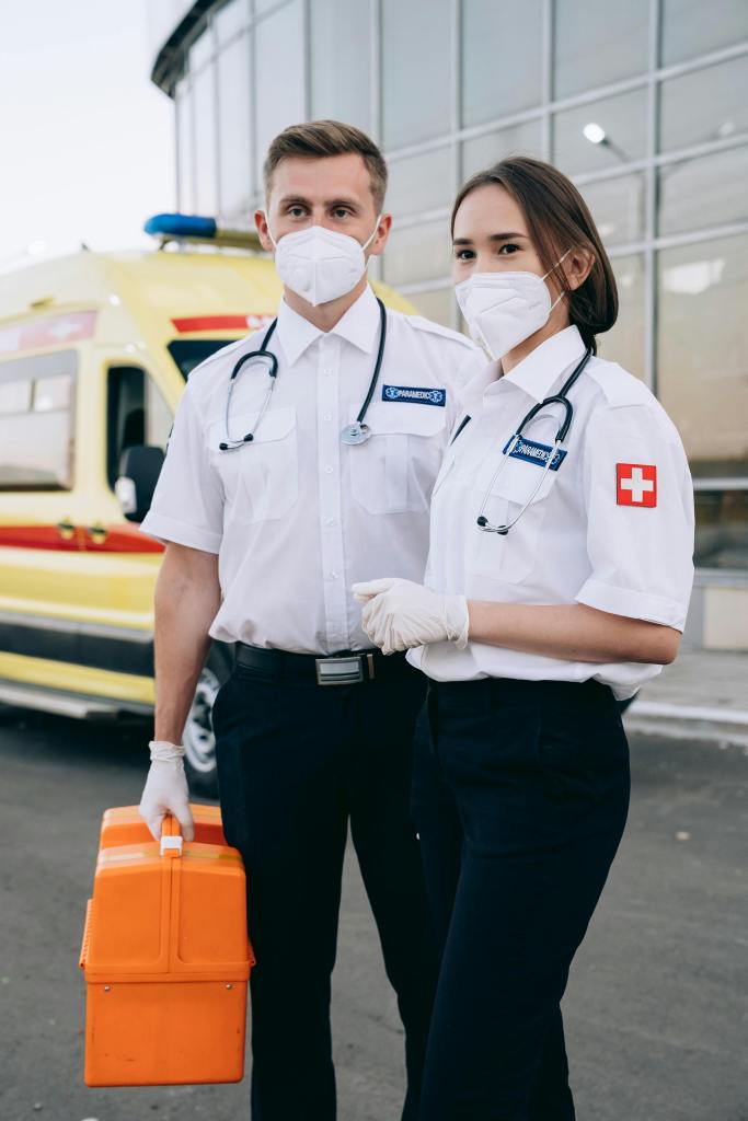 Two Paramedic friends getting ready to run a call with their orange drug box in hand. 