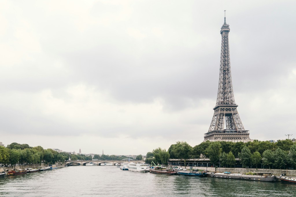Eiffle Tower overlooking a river in Paris France.
