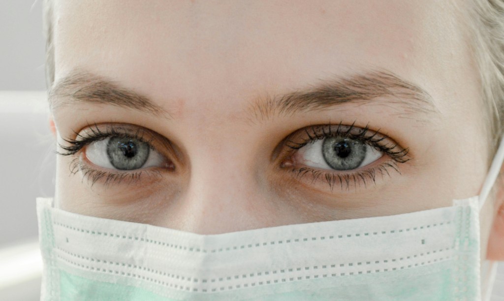 Close-up of a nurse wearing a mask with her eyes visible. 