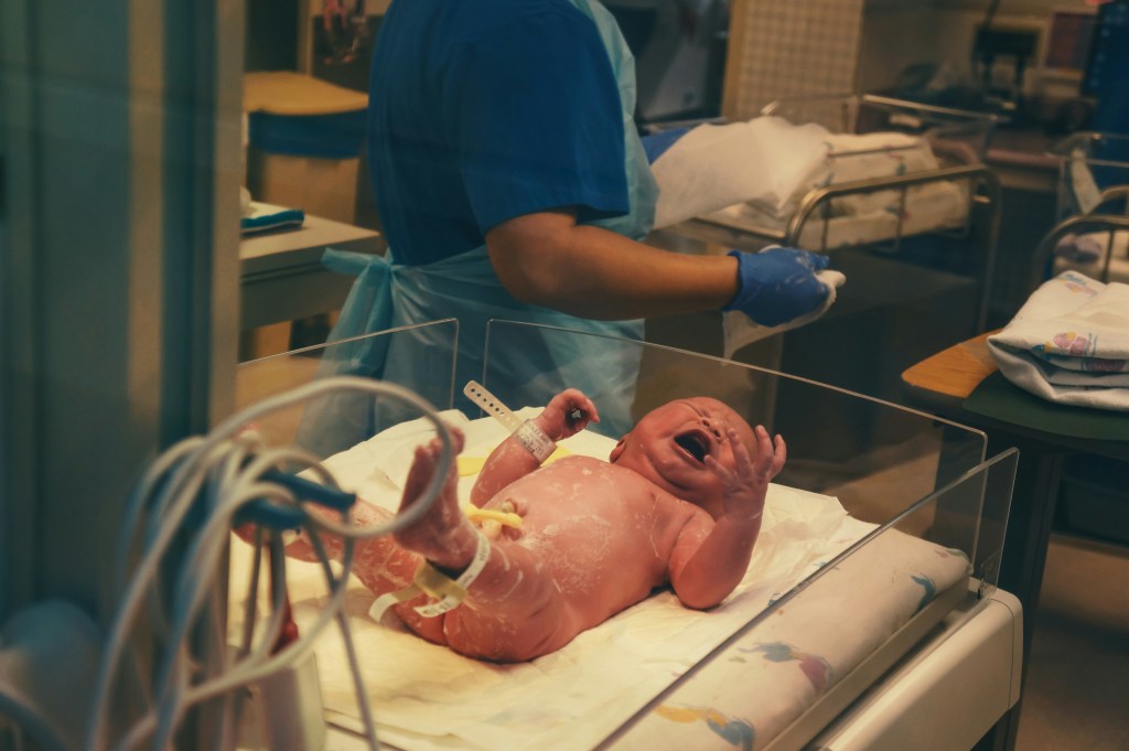 A newborn baby crying in the hospital after birth. 