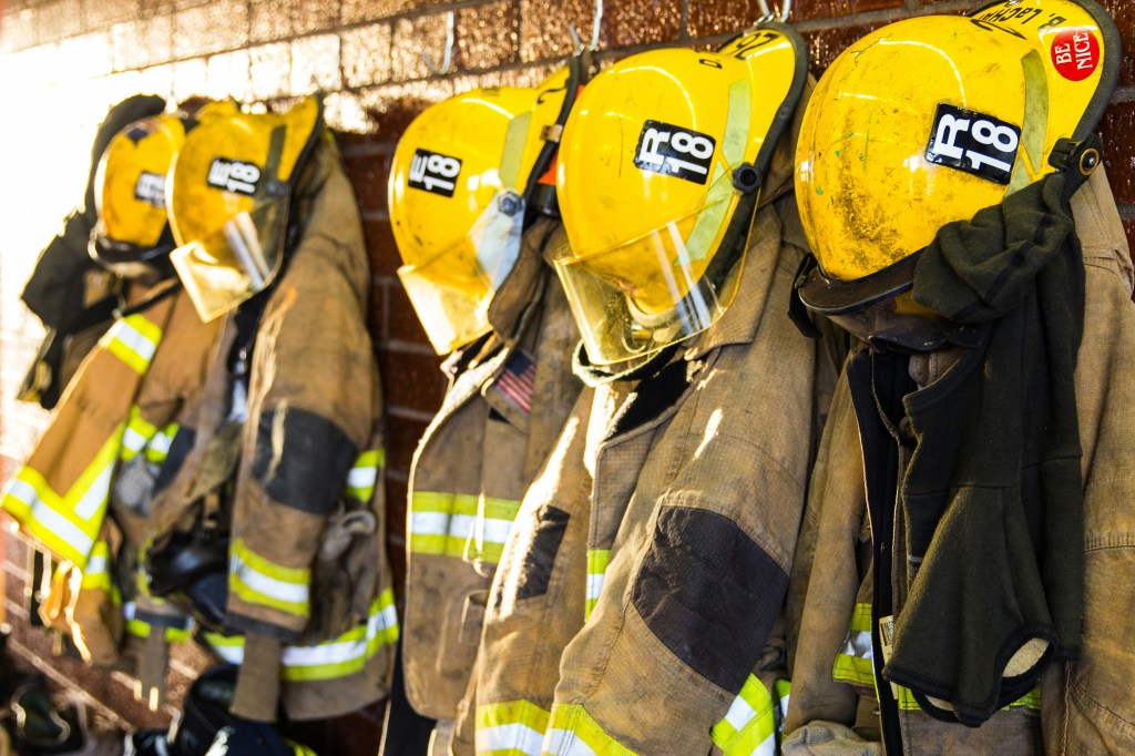 Paramedic Firefighters hanging their turnouts on coat racks to keep them clean and dry. 